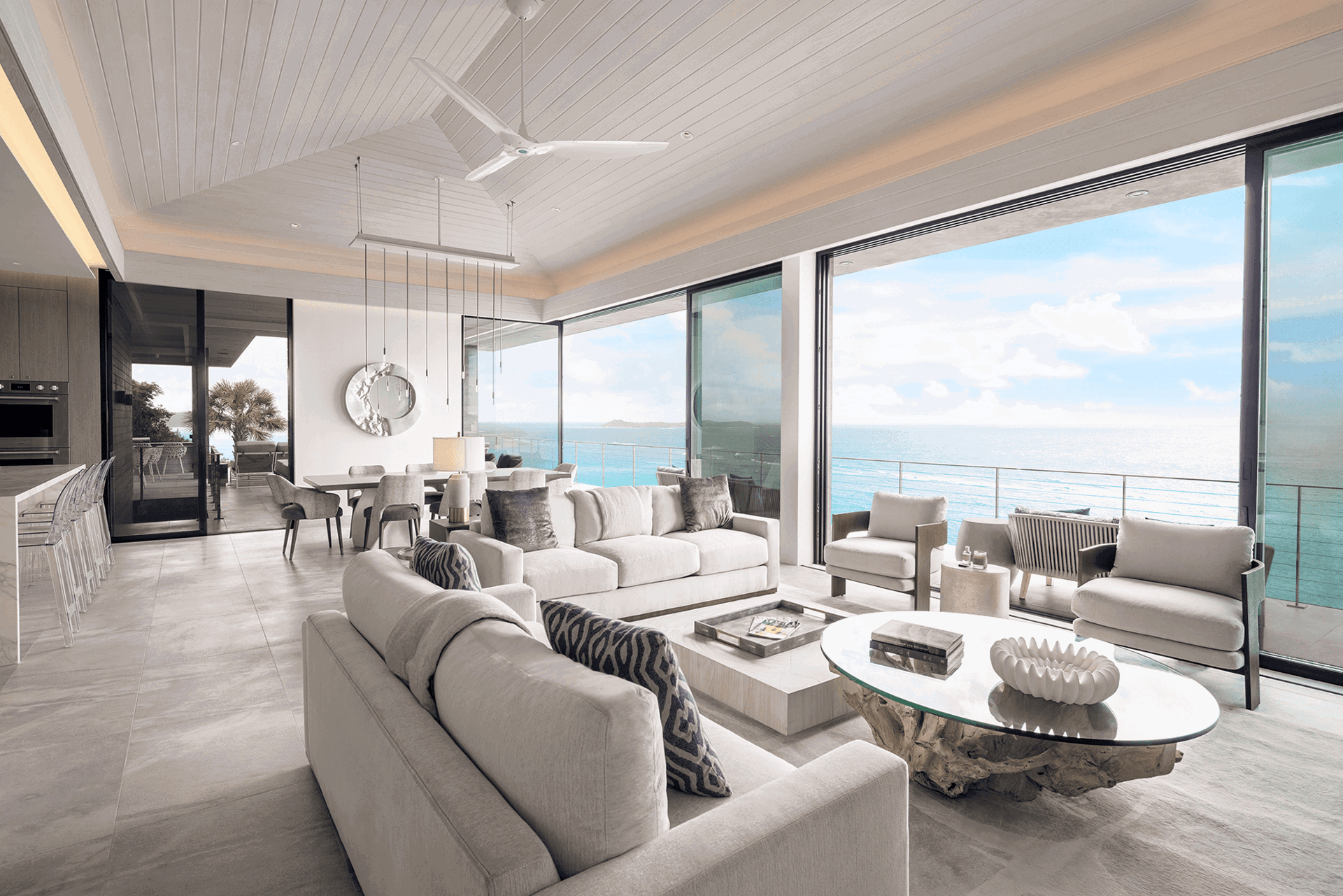 Bright open-concept living room with expansive sliding glass doors overlooking a coastal ocean view.