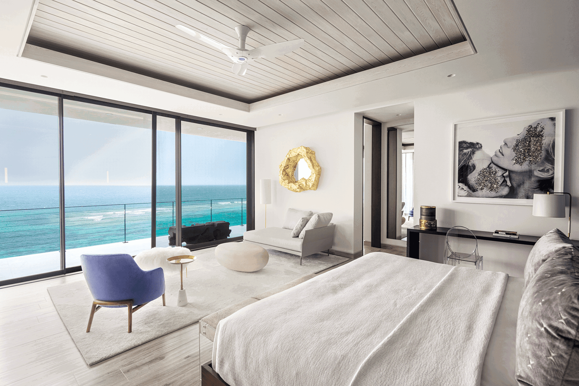 Bedroom with floor-to-ceiling sliding glass doors overlooking the ocean.