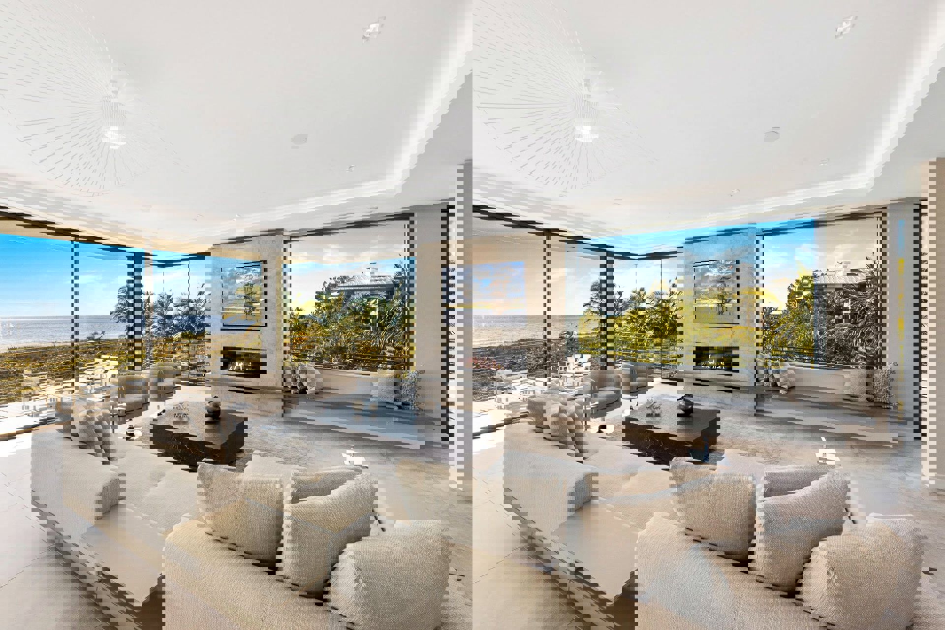Contemporary living room with floor-to-ceiling glass wall systems framing ocean views and indoor-outdoor connection.